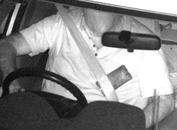 photo of a driver in a car with a phone on his body
